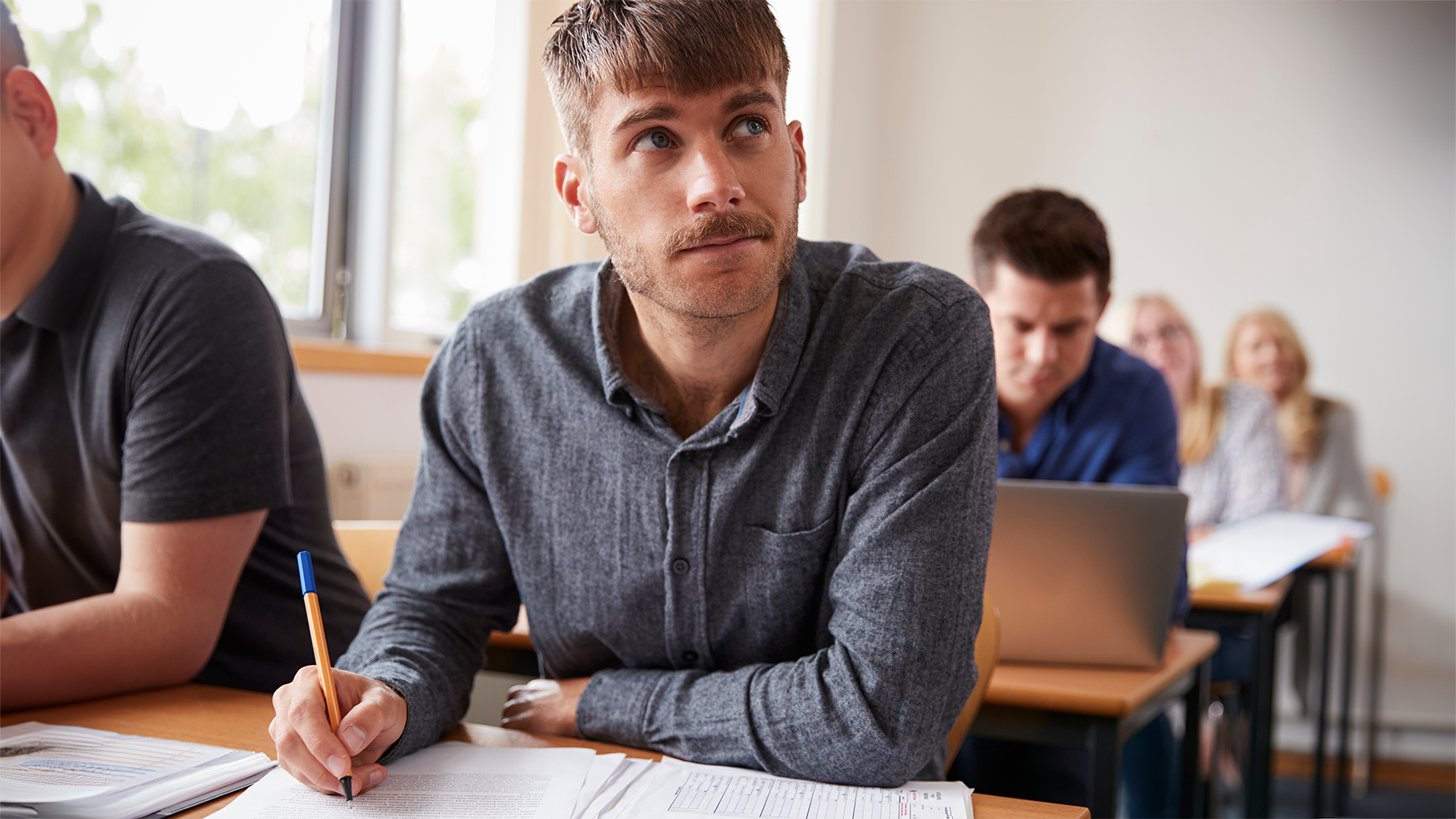 Ein junger Mann schreibt sich in einer Weiterbildung etwas auf