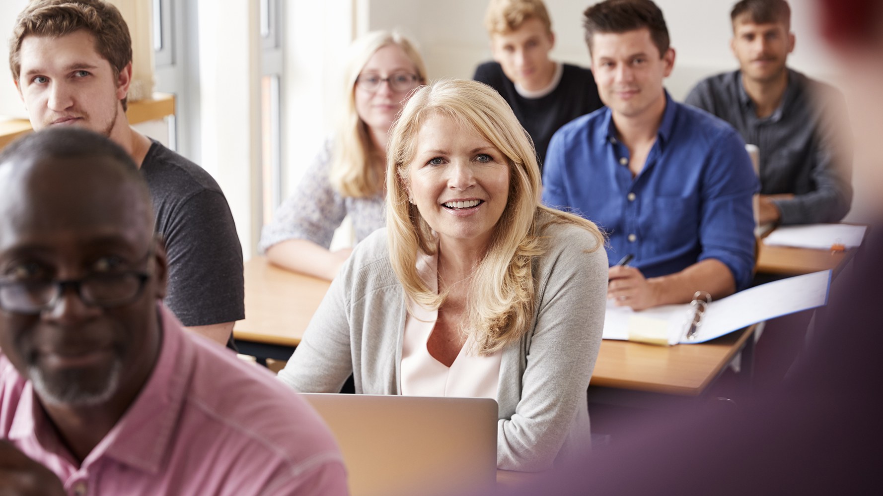 Erwachsene sitzen im Schulzimmer an einer Weiterbildung